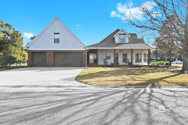 view of front of home with a garage, a porch, and a front yard