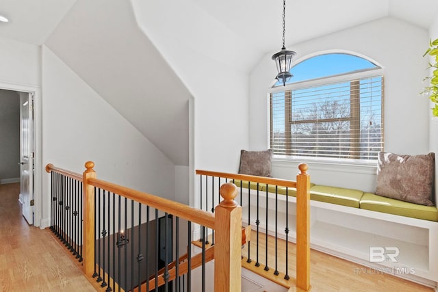 hallway featuring lofted ceiling and light hardwood / wood-style flooring