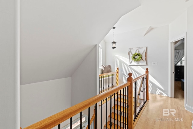 hallway featuring light hardwood / wood-style floors and lofted ceiling