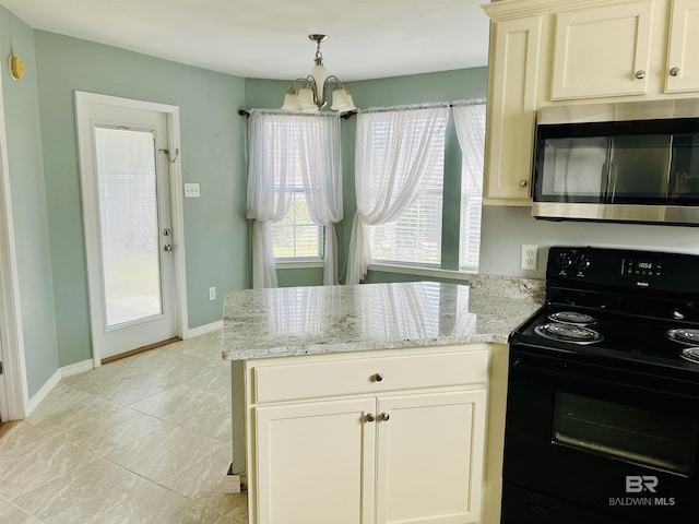 kitchen with light stone counters, stainless steel microwave, baseboards, and black range with electric stovetop