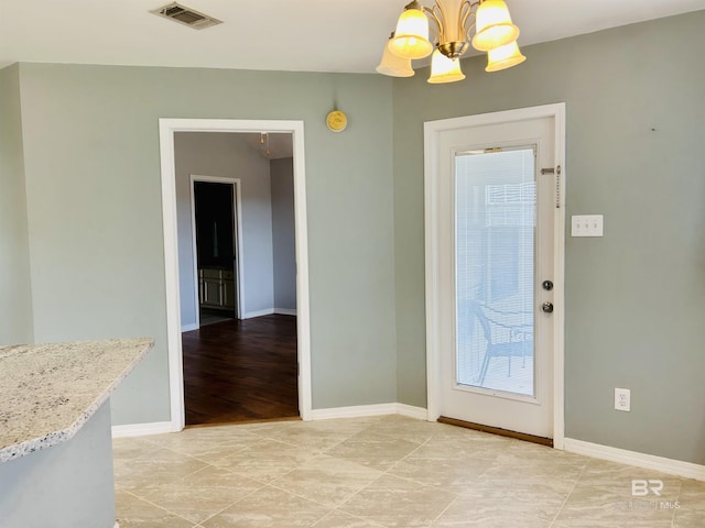 interior space with light tile patterned floors and an inviting chandelier