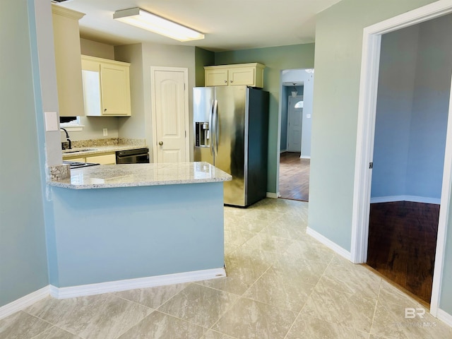 kitchen featuring dishwashing machine, light stone counters, a peninsula, stainless steel fridge with ice dispenser, and a sink