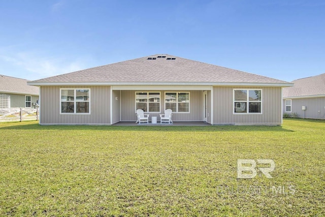 back of house featuring a lawn and a patio area