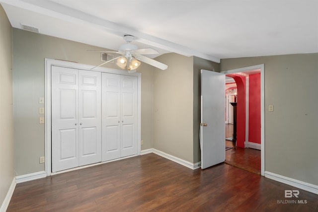 unfurnished bedroom with ceiling fan, a closet, dark hardwood / wood-style floors, and lofted ceiling