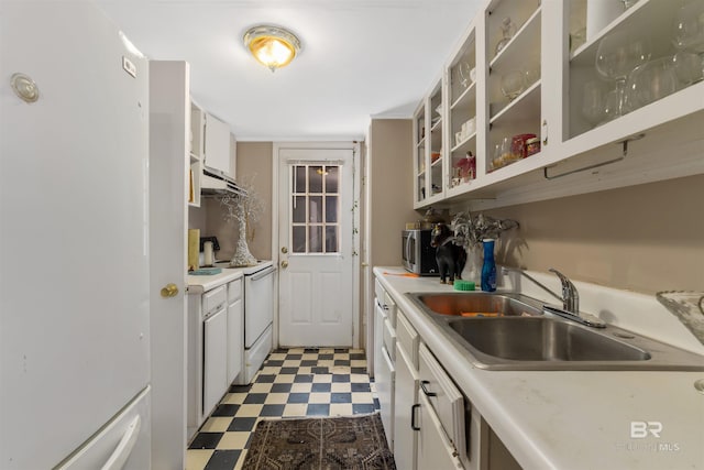 kitchen with white cabinets, white fridge, stove, and sink