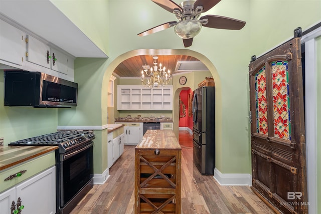 kitchen featuring wooden counters, white cabinets, a barn door, light wood-type flooring, and stainless steel appliances