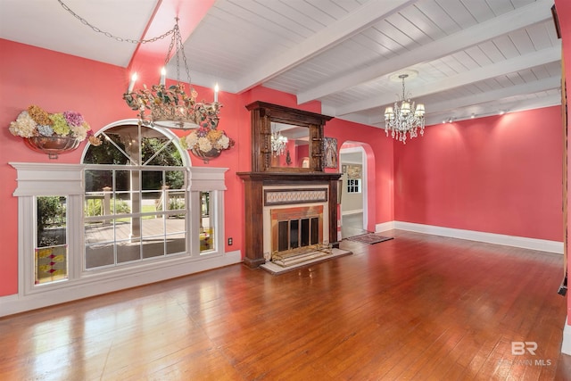 unfurnished living room with beam ceiling, a high end fireplace, wood-type flooring, and an inviting chandelier