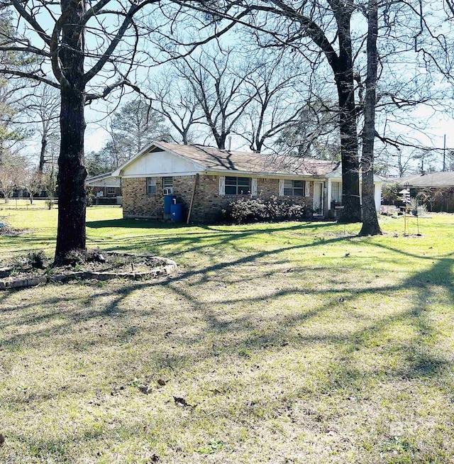 view of front of house with brick siding and a front yard