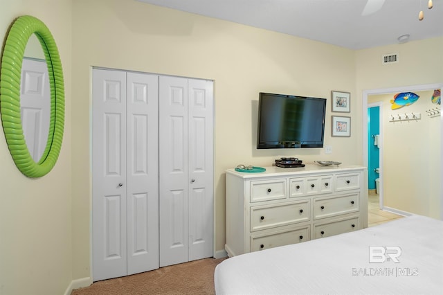 bedroom featuring a ceiling fan, visible vents, baseboards, a closet, and light colored carpet