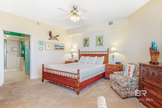 carpeted bedroom featuring ceiling fan, visible vents, baseboards, and connected bathroom