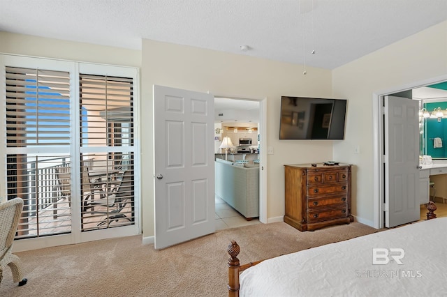 bedroom with carpet, baseboards, ensuite bath, access to exterior, and a textured ceiling