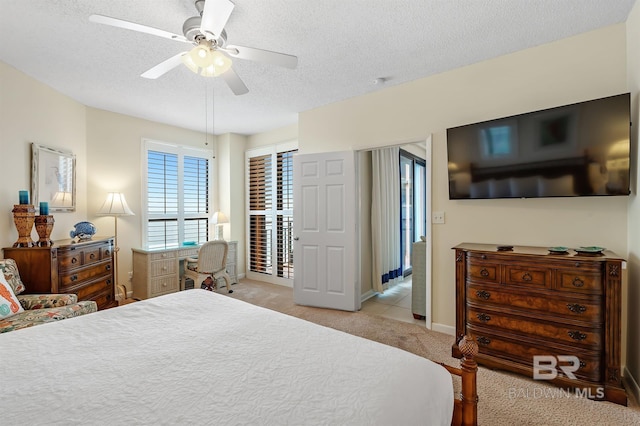 bedroom featuring ceiling fan, light colored carpet, baseboards, and a textured ceiling