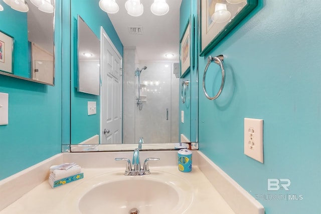 bathroom featuring visible vents, a stall shower, and vanity