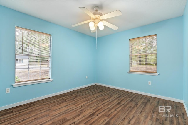 empty room with ceiling fan, dark hardwood / wood-style flooring, and plenty of natural light