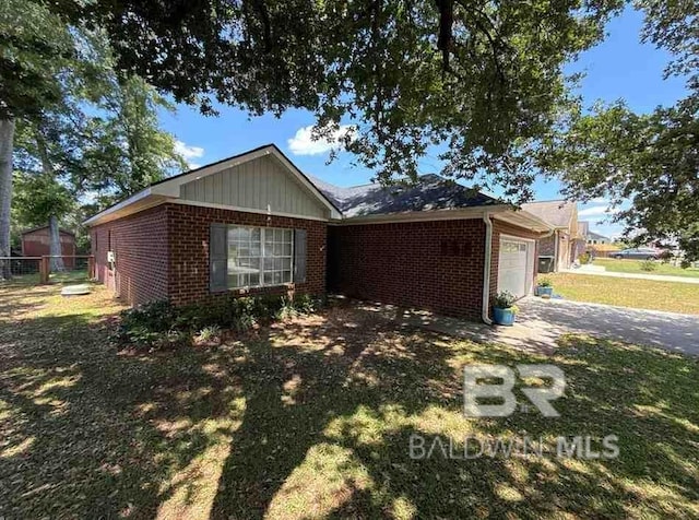view of front of home featuring brick siding, a garage, driveway, and fence