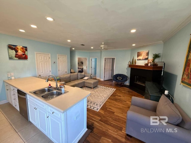 kitchen featuring a sink, open floor plan, ornamental molding, dishwasher, and recessed lighting