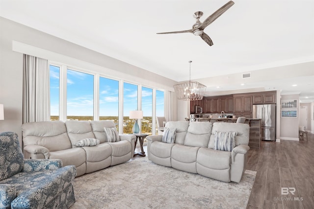 living room featuring ceiling fan with notable chandelier and light hardwood / wood-style floors