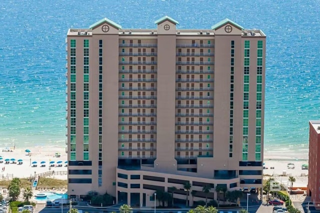 view of building exterior featuring a view of the beach and a water view