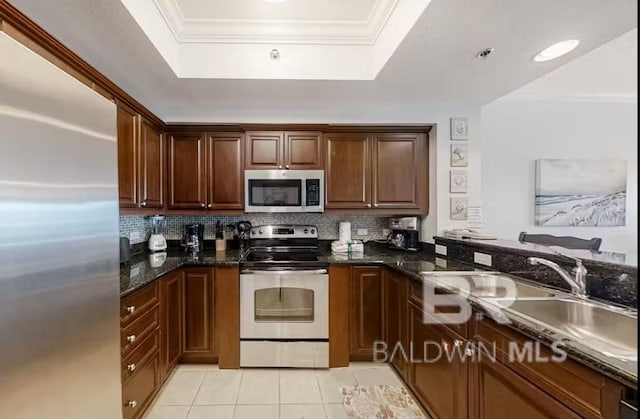401 E Beach Blvd Unit 1804, Gulf Shores, AL 36542 - kitchen with appliances with stainless steel finishes, a tray ceiling, tasteful backsplash, ornamental molding, and light tile patterned floors