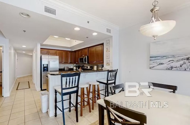 401 E Beach Blvd Unit 1804, Gulf Shores, AL 36542 - kitchen featuring appliances with stainless steel finishes, dark countertops, decorative backsplash, crown molding, and light tile patterned floors