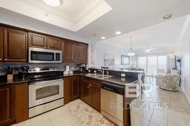 401 E Beach Blvd Unit 1804, Gulf Shores, AL 36542 - kitchen featuring stainless steel appliances, open floor plan, a sink, light tile patterned flooring, and a peninsula