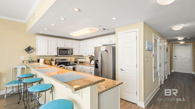 1524 W Beach Blvd Unit 603, Gulf Shores, AL 36542 - kitchen with stainless steel appliances, a peninsula, baseboards, white cabinetry, and recessed lighting