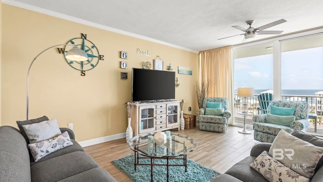 1524 W Beach Blvd Unit 603, Gulf Shores, AL 36542 - living room featuring a ceiling fan, ornamental molding, wood finished floors, baseboards, and expansive windows