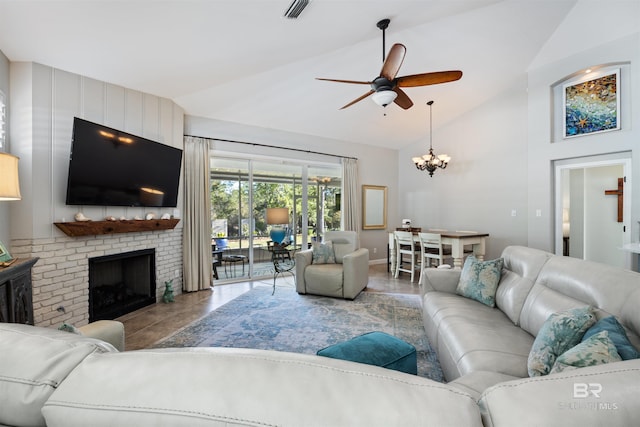 living room featuring ceiling fan with notable chandelier, a brick fireplace, and lofted ceiling