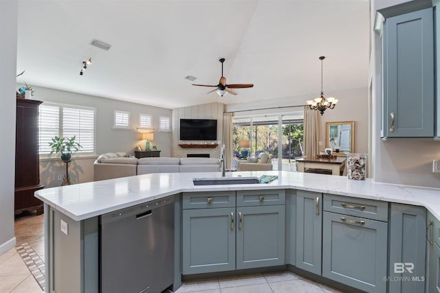 kitchen with stainless steel dishwasher, ceiling fan with notable chandelier, light tile patterned flooring, and kitchen peninsula