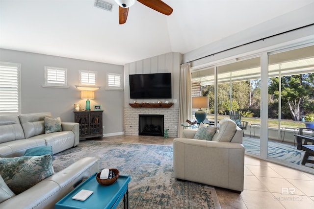 tiled living room with a fireplace, ceiling fan, and lofted ceiling