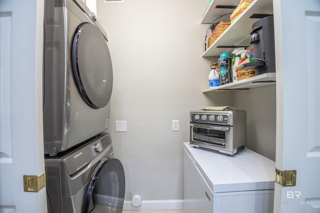 washroom featuring stacked washing maching and dryer