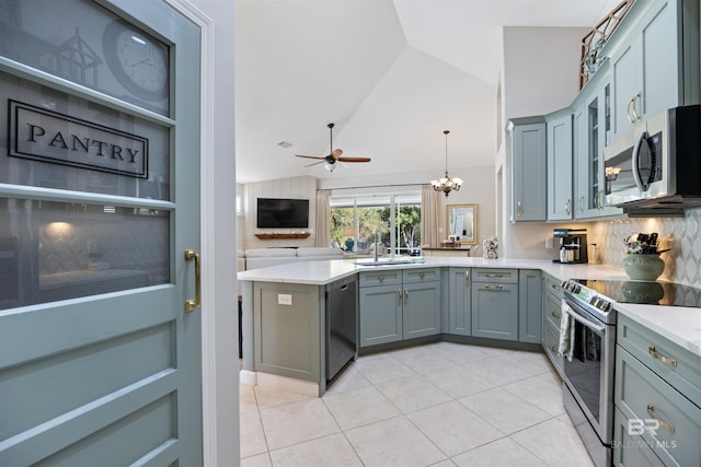 kitchen featuring kitchen peninsula, appliances with stainless steel finishes, ceiling fan with notable chandelier, hanging light fixtures, and lofted ceiling