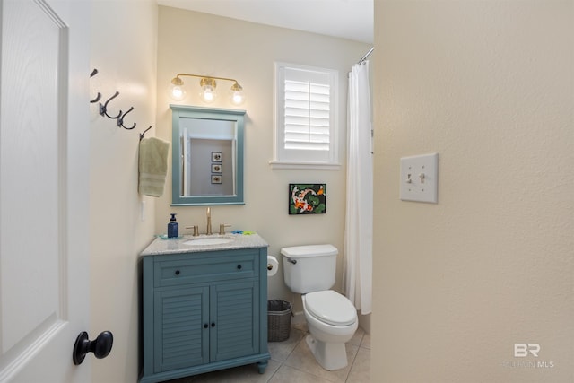 bathroom with toilet, vanity, and tile patterned floors