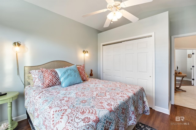 bedroom with ceiling fan, dark hardwood / wood-style floors, vaulted ceiling, and a closet