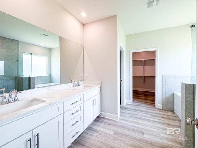 23850 Shadowridge Dr, Daphne, AL 36526 - bathroom with a bath, a shower stall, double vanity, and wood finished floors
