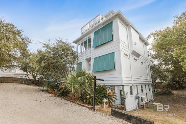 view of home's exterior with fence and a balcony