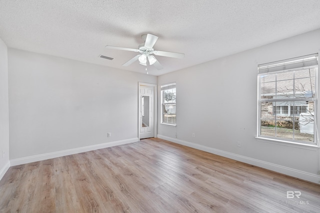 unfurnished room with ceiling fan, a textured ceiling, and light wood-type flooring