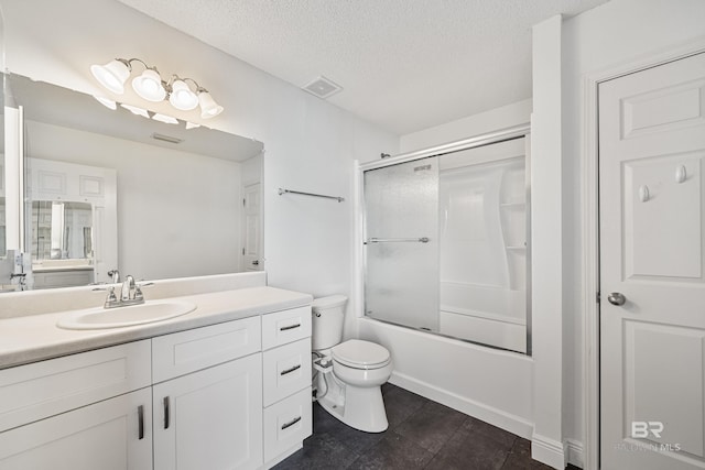 full bathroom featuring toilet, vanity, shower / bath combination with glass door, and a textured ceiling