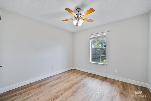 spare room with ceiling fan, a textured ceiling, and light wood-type flooring