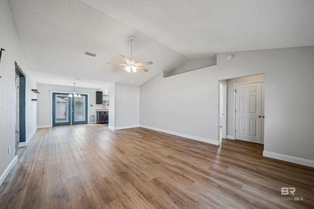 unfurnished living room with a textured ceiling, wood-type flooring, ceiling fan, and vaulted ceiling