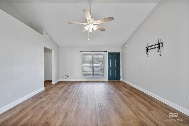 empty room featuring high vaulted ceiling, ceiling fan, and light wood-type flooring