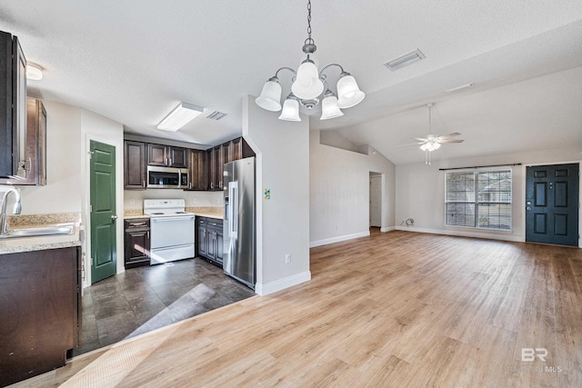 kitchen featuring sink, ceiling fan with notable chandelier, appliances with stainless steel finishes, dark brown cabinetry, and decorative light fixtures