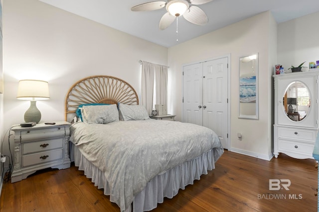 bedroom featuring ceiling fan, baseboards, dark wood finished floors, and a closet