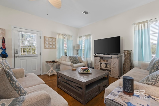 living area with a wealth of natural light, dark wood finished floors, and visible vents