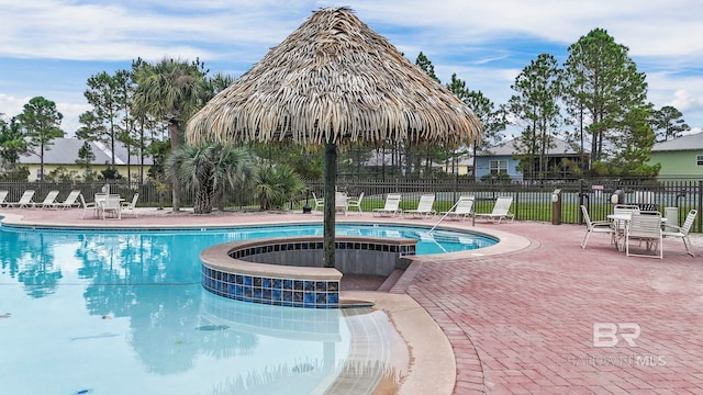 pool featuring a jacuzzi, fence, and a patio