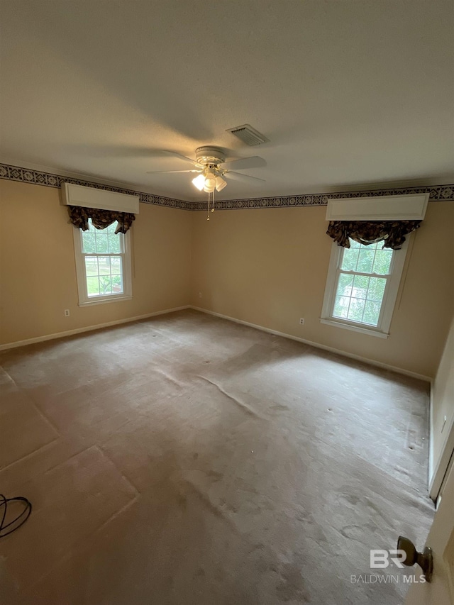 unfurnished room featuring visible vents, carpet flooring, baseboards, and ceiling fan