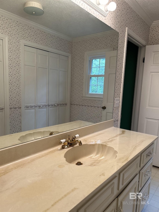 bathroom featuring vanity, wallpapered walls, tile patterned flooring, a textured ceiling, and crown molding