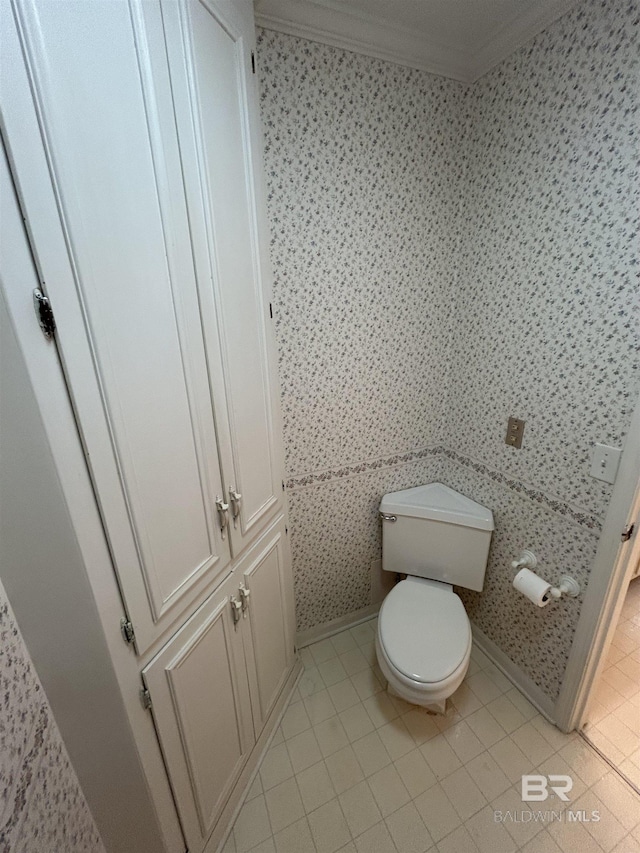 bathroom featuring tile patterned floors, baseboards, toilet, and ornamental molding