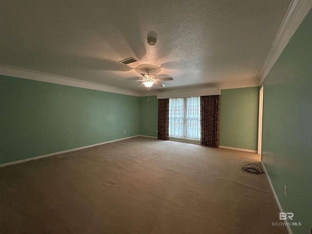 carpeted spare room with visible vents, baseboards, a textured ceiling, and crown molding