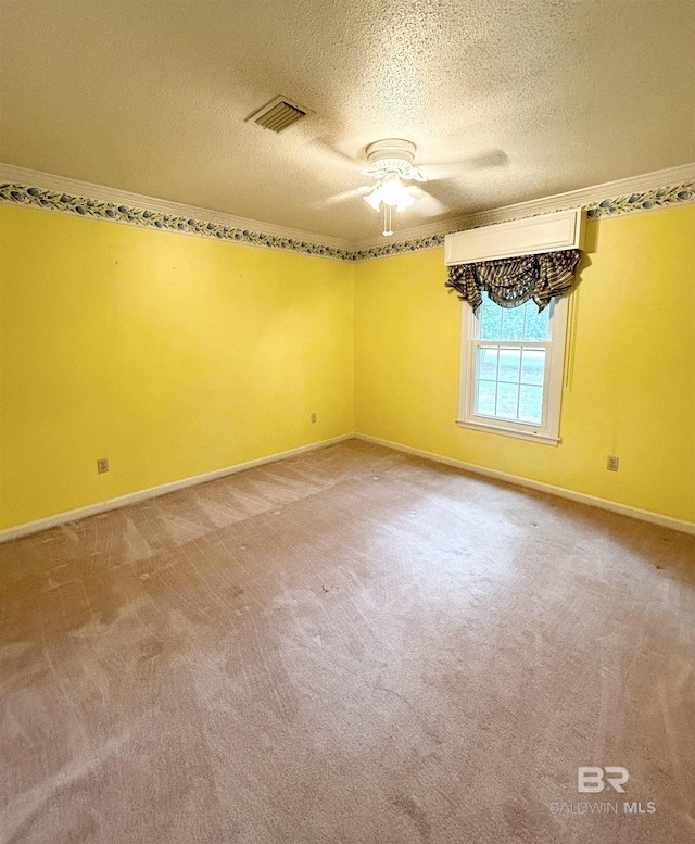 empty room featuring visible vents, carpet flooring, a textured ceiling, and baseboards